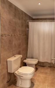 y baño con aseo y cortina de ducha. en Departamento Hosteria del Cerro en San Carlos de Bariloche