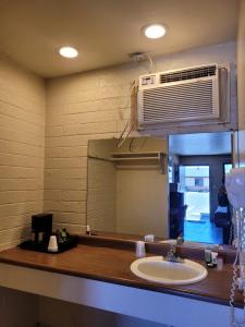 eine Badezimmertheke mit einem Waschbecken und einem Spiegel in der Unterkunft Westerner Motel in Williams