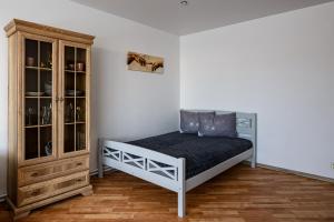 a bedroom with a bed and a cabinet at SUNSET urban apartment in Liepāja
