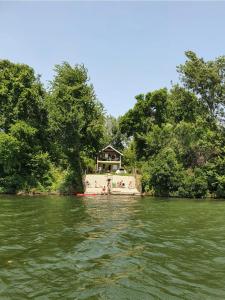 ein Haus am Ufer eines Flusses mit Bäumen in der Unterkunft green house at silver lake in Ostrovo