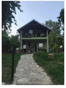 a house with a stone path in front of it at green house at silver lake in Ostrovo