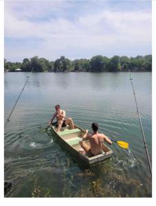 Twee mannen roeien een boot in het water. bij green house at silver lake in Ostrovo