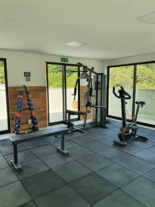 a gym with several treadmills and machines in a room at Cobertura Piemonte in Itaipava