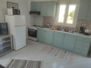 uma cozinha com armários azuis e um frigorífico branco em Bee life apts, Sweet house em Kókkinos Pírgos
