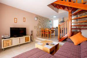 ein Wohnzimmer mit Sofa und Fernseher in der Unterkunft Bungalow Costa Adeje El Cortijo 2-9 in Playa de las Americas