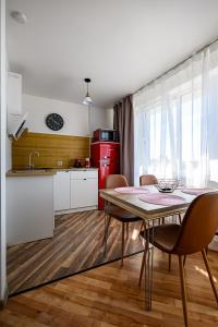 a kitchen with a table and chairs in a room at SUNSET urban apartment in Liepāja