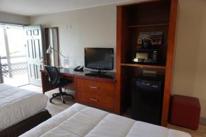 Habitación de hotel con cama y escritorio con TV. en Harvest Drive Family Inn - Renovated Rooms en Gordonville