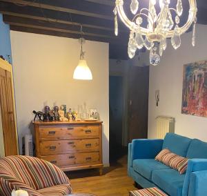 un salon avec un canapé bleu et un lustre dans l'établissement Casa Torrazzo, à Pisogne