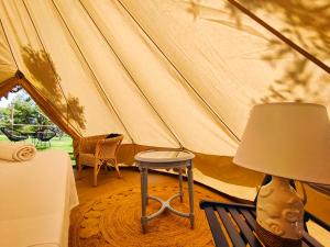 a tent with a table and a chair and a lamp at Tende Glamping Vista Mare Marina Serra in Marina Serra +68 photos