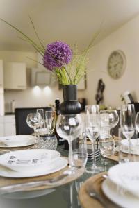 a table with glasses and a vase with a purple flower at Ferienwohnung an der Steinfurter Aa in Steinfurt
