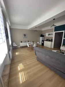 uma sala de estar com um sofá e uma sala de jantar em Le Rétro em Saint-Laurent-sur-Saône
