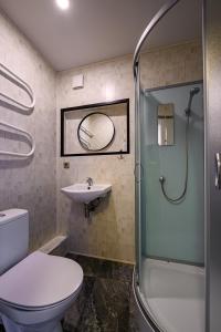 a bathroom with a shower and a toilet and a sink at SUNSET urban apartment in Liepāja