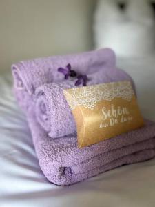 een stapel paarse handdoeken bovenop een bed bij Ferienhaus Lavendel in Obergurig