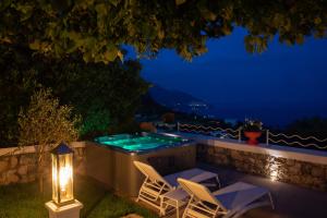 einen Hinterhof mit einem Whirlpool und Stühlen in der Nacht in der Unterkunft Villa Veronica Luxury Suite in Amalfi coast in Piano di Sorrento