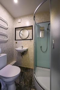 a bathroom with a shower and a toilet and a sink at SUNSET urban apartment in Liepāja