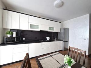 a kitchen with white cabinets and a table and chairs at Apartment on Belvedere in Ivano-Frankivsʼk +21 photos