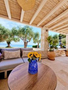 uma sala de estar com uma mesa com um vaso de flores em Villa Teresa Luxury Suites em Thásos