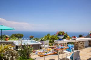 eine Terrasse mit einem Tisch, Stühlen und einem Pool in der Unterkunft Villa Veronica Luxury Suite in Amalfi coast in Piano di Sorrento