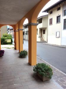 un arco con dos macetas en una calle en Al Borgo Affittacamere en Venzone