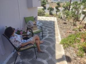 Dos mujeres sentadas en sillas en un patio en Bee life apts, Sweet house, en Kokkinos Pirgos