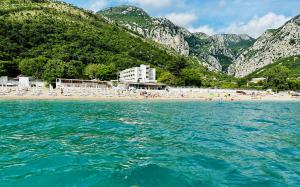 a view of a beach with chairs and the water at Apartmani Neo in Sutomore
