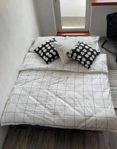 a bed with black and white pillows on it at City Center Apartment in Katowice