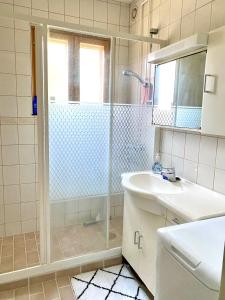 ein Bad mit einer Dusche und einem Waschbecken in der Unterkunft Joensuu keskustaneliö in Joensuu