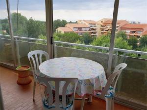 een tafel en stoelen op een balkon met uitzicht op de stad bij Studio Argelès-sur-Mer, 1 pièce, 2 personnes - FR-1-388-151 in Argelès-sur-Mer