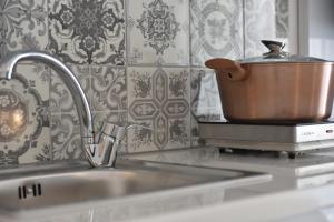 a pot sitting on a counter next to a kitchen sink at Ilion Luxury Studios in Asprovalta