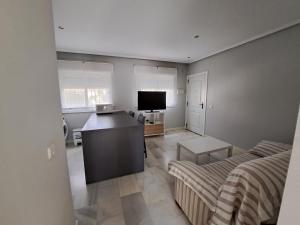 sala de estar con sofá y mesa en una habitación en Apartamento Pinares del atlantico, en Chiclana de la Frontera