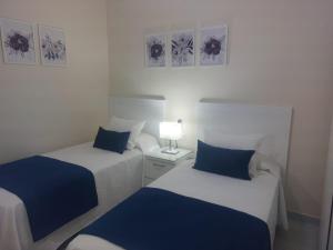 two beds in a room with blue and white at La Palma in Tarajalejo