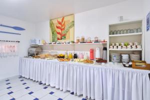 a buffet line with food on it in a restaurant at Pousada Sanremo Inn in Ubatuba