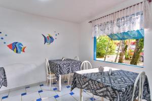 Un comedor con dos mesas y una ventana. en Pousada Sanremo Inn, en Ubatuba