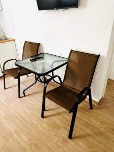 two chairs and a glass table in a room at Apartmani Neo in Sutomore