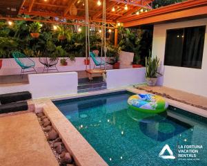 una piscina con una balsa inflable en una casa en Villa Cocos la Fortuna, en Fortuna
