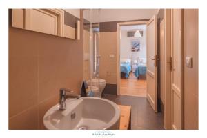 a bathroom with a sink and a hallway with a room at Ancóramare in Stintino