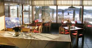 ein Restaurant mit Tischen und Stühlen und einem großen Fenster in der Unterkunft Humboldt-Haus in Achberg