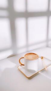 a cup of coffee on a plate with a spoon at House in Lviv in Lviv