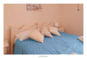 a bedroom with a bed with blue sheets and pillows at Ancóramare in Stintino