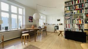 a living room with a table and a book shelf with books at ApartmentInCopenhagen Apartment 1543 in Copenhagen