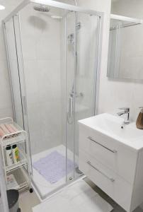 a white bathroom with a shower and a sink at Apartment D&L in Plitvička Jezera
