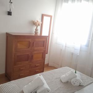 a bedroom with two beds and a dresser and a mirror at Toledo Enamora Dos - PARKING INCLUIDO in Toledo