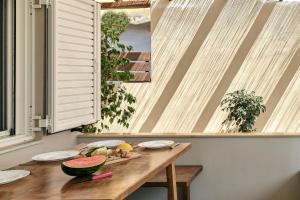 a wooden table with a bowl of fruit on it at 2 bedroom Villa with heated swimming pool-Spa whirlpool-BBQ! in Melidhónion