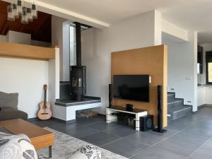 a living room with a flat screen tv and a guitar at Villa Stadi in Nikiti +41 photos