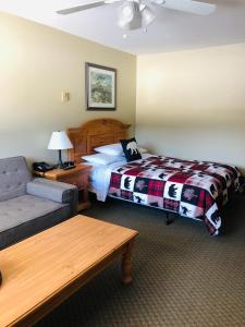 a hotel room with a bed and a couch at Parkway Motel in Wawa