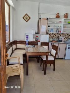 a room with a table and chairs and a kitchen at RAINFORT APART salda gölü kiralık apart in Yeşilova