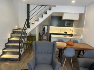 a kitchen and dining room with a table and stairs at Palmela cozy in Palmela