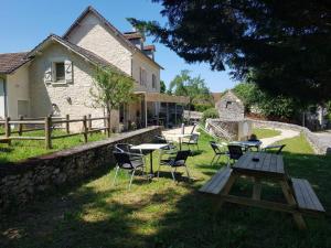 a picnic table and chairs in front of a house at Auberge De Carlucet in Carlucet