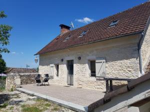 a stone house with two chairs on a patio at Auberge De Carlucet in Carlucet