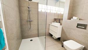 a bathroom with a shower with a toilet and a sink at CoeurDeSable - Appartement T3 Hyper Centre Arcachon - Parking in Arcachon
